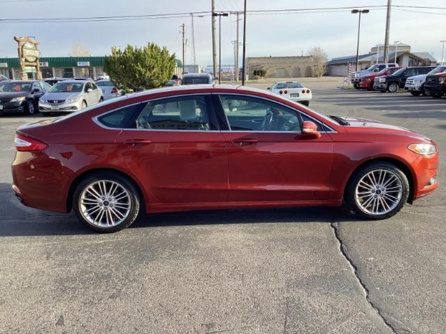 2014 Sunset /Charcoal Black Ford Fusion SE (3FA6P0H95ER) with an 2.0L L4 DOHC 16V engine, 5-Speed Automatic transmission, located at 1235 N Woodruff Ave., Idaho Falls, 83401, (208) 523-1053, 43.507172, -112.000488 - Design: The Fusion features a sleek exterior design that sets it apart from other midsize sedans in its class. With its modern styling, it offers a sophisticated appearance. Performance: The SE trim typically comes with a range of engine options, including fuel-efficient four-cylinder engines and m - Photo#5